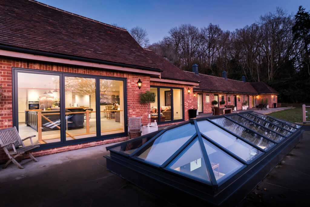 Black Folding Door Installation On Modern Brick Home With Lighting
